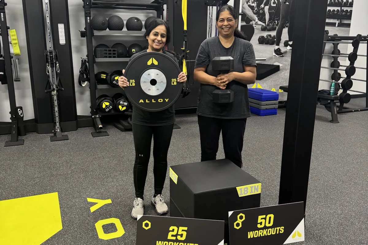 Coach guiding a member through a customized workout at Alloy Cary