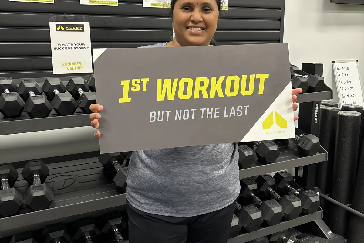 Member holding a first workout sign at Alloy Cary